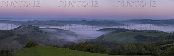 Sunrise with foggy atmosphere in hilly landscape, province of Siena, Tuscany, Italy