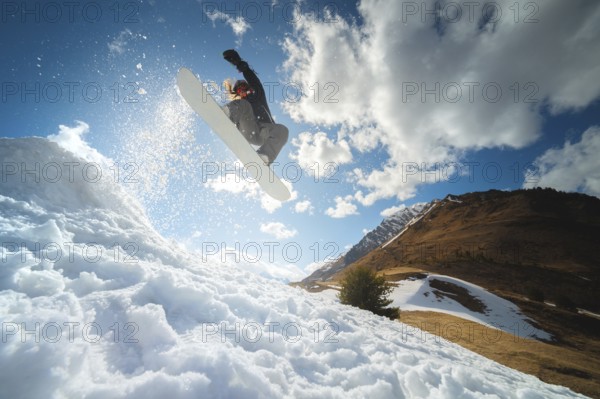 Extreme winter sports. Young professional woman snowboarder rides a halfpipe. Jumps from a halfpipe trampoline in the sun, performs tricks and turns with grabs in a sunny winter
