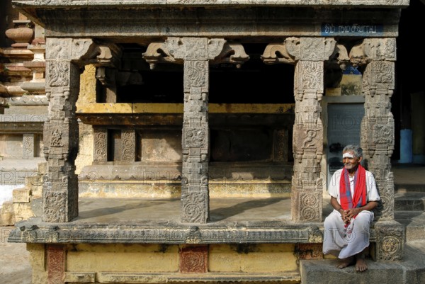 Old man sitting in front of Kandarathithan Gopuram in Virudhagireeswarar Shiva temple in Virudhachalam, Tamil Nadu, South India, India, Asia