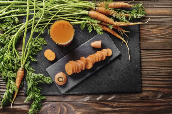 Top view at fresh organic vegetarian carrot juice on wooden kitchen table