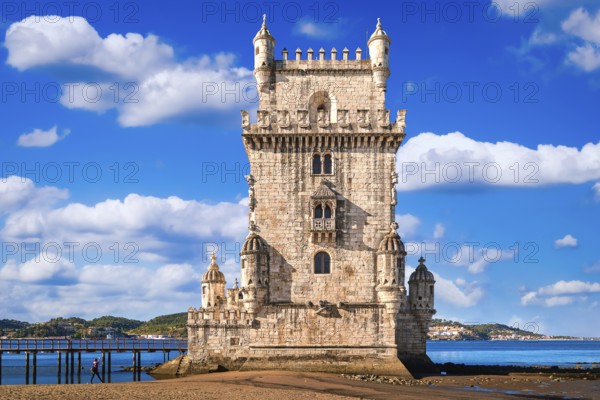 Landmark of Belem tower, Lisbon, Portugal at blue summer day sky with clouds. Medieval fortification on Tagus river in late Gothic or Manueline style, UNESCO world heritage site, Age of Discoveries, tourist attraction, Portuguese seafaring history