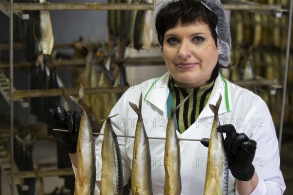 September 18, 2020. Belarus, Gamil. Fish factory.Fish factory worker holds smoked fish
