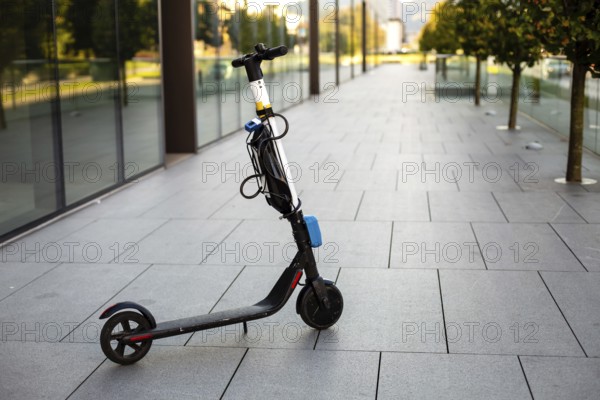 Empty electric scooter parket in the city at the business building