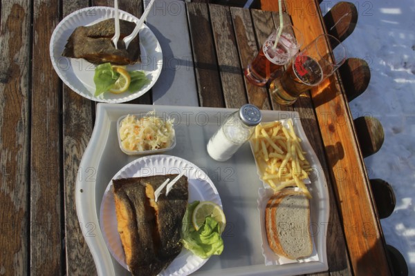 Eating fried fish outside, winter at the Baltic Sea