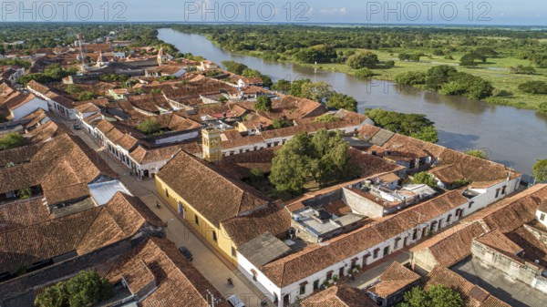 Aerial view of the historic town Santa Cruz de Mompox in sunlight with river and green sourrounding, World Heritage