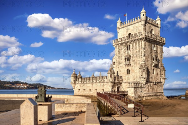 Landmark of Belem tower, Lisbon, Portugal at blue summer day sky with clouds. Medieval fortification on Tagus river in late Gothic or Manueline style, UNESCO world heritage site, Age of Discoveries, tourist attraction, Portuguese seafaring history