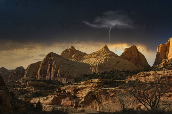 Large rocks in a desert landscape at dusk with a single flash in the sky, Monument Valley, Maxican Hat, Utah, America
