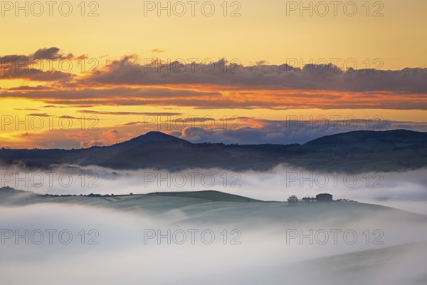 Farmhouse near in Val d'Orcia at foggy dawn, Tuscany, Italy