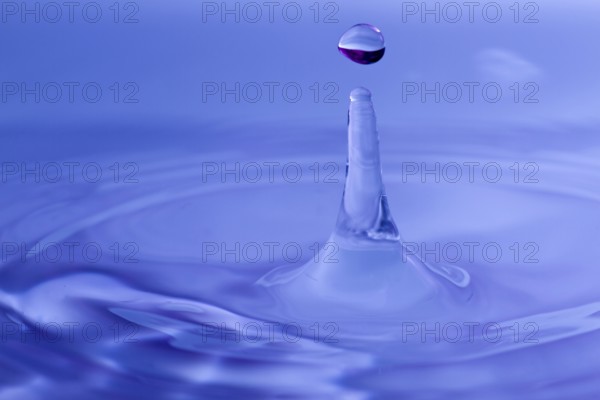 Macro of a single drop of water on a blue background