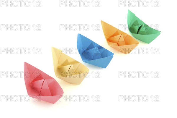 Colorful folder paper boats isolated over white