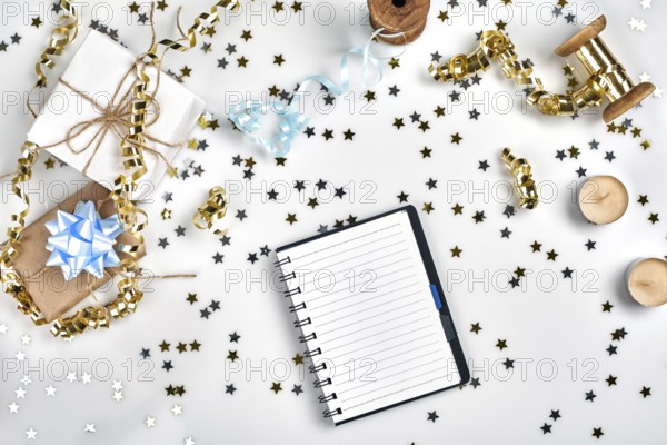 Flat Lay Christmas or Party Background with colored ribbons, decorations, confetti, and wrapping paper. Notepad for Text in Middle. Perfect backdrop for your design