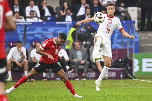 BERLIN, GERMANY - JUNE 21, 2024: Euro 2024 Groupe D match Poland vs Austria 1:3. In action Phillipp Mwene (L) Przemyslaw Frankowski (R)