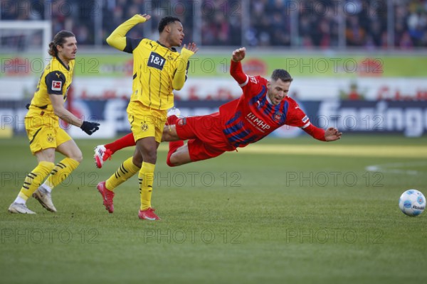 Germany: Soccer 1st Bundesliga, Matchday 20 - 1. FC Heidenheim vs. Borussia Dortmund - Voith-Arena Heidenheim: Marvin PIERINGER 1. FC Heidenheim right on the ball is fouled by Julien DURANVILLE Borussia Dortmund, Marvin PIERINGER 1. FC Heidenheim is literally in the air, left outside Marcel SABITZER Borussia Dortmund watches the action