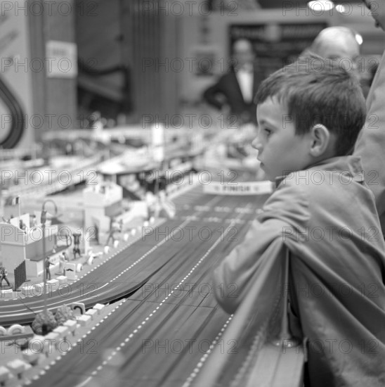 Toys in the 1960s. A boy fascinated by a miniature racing track by Scalextric. You could race cars with a remote control and competing agains each other was the what the game was about. Sweden 1962