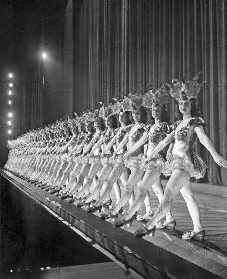 Ballet girls in New York. A long line of dancing girls on stage at Radio City Music Hall in New York are moving together synchronized to the music. 1940s