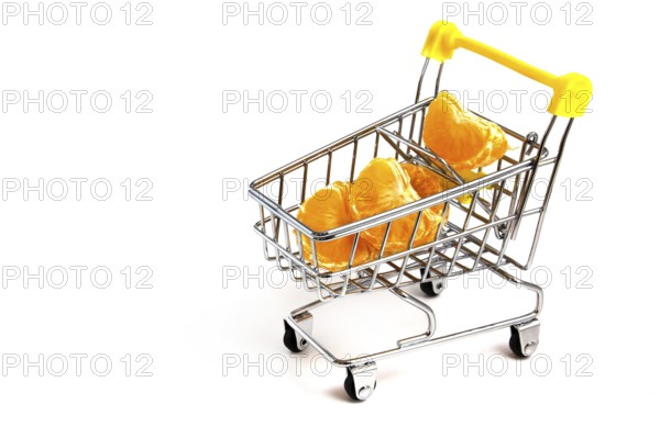 Particles of peeled tangerine in a shopping cart isolated on white background