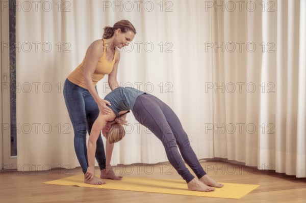 An image of two women doing yoga at home