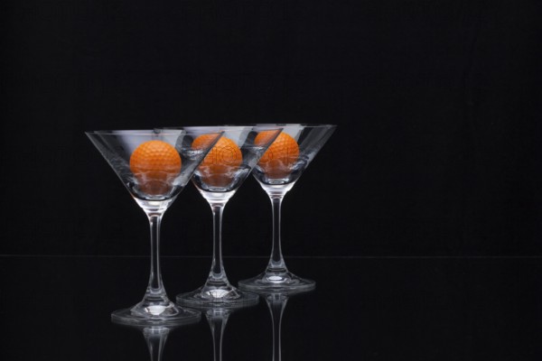 Three glasses of champagne with golf balls