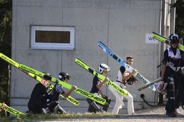 Ski jumpers on their way to the inrun tower at the Alpencup Ski Jumping Hinterzarten 2024, Hinterzarten, Germany / Germany