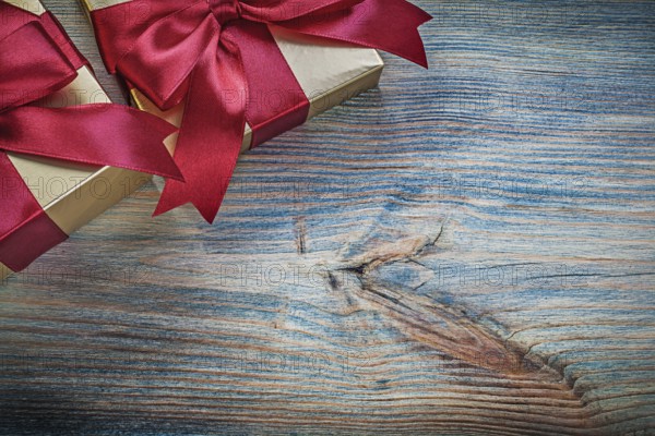 Gift boxes with tied bows on vintage wooden board holidays concept