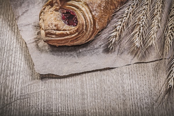 Golden wheat rye ears baked rolls on wooden board