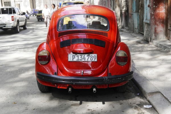 Red Volkswagen Beetle on a city street, Cuba, Greater Antilles, Caribbean, Central America, America