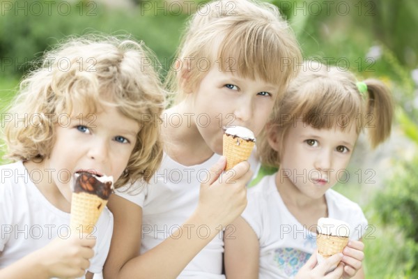 Happy friends eating ice-cream outdoors in spring park