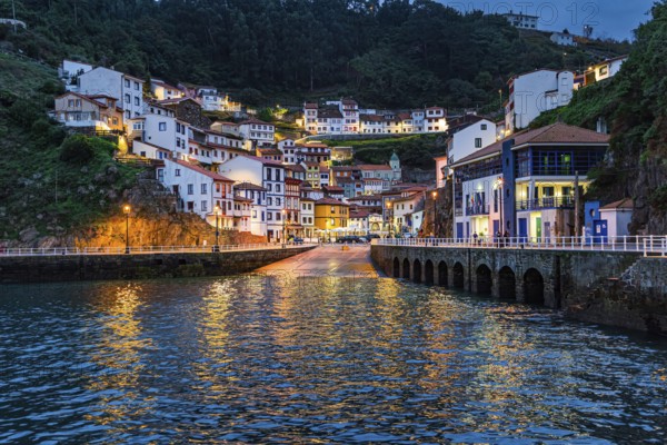Picturesque reflection in sea water. Evening twilight in Cudillero. The village is an amphitheater around the ocean bay. Magical Asturias. Spain