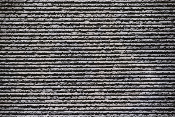 Close-up of a grey clinker brick façade made of rough stones on the façade of a building