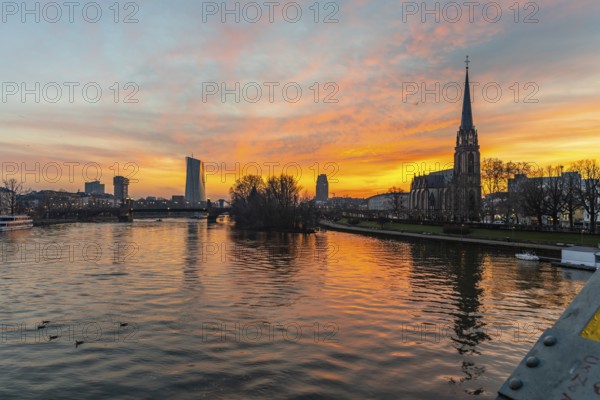 View across the River Main to the ECB and the Protestant Church of the Epiphany. Sunrise in the background of the buildings. Taken in the morning in Frankfurt am Main