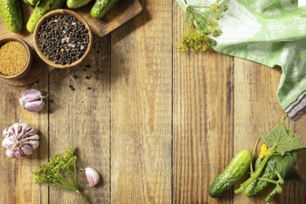 Wooden background with cucumbers prepared for pickling and ingredients for the marinade. Canned vegetables. Mock up. Harvest preserving. Fermented food