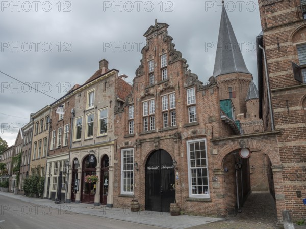Historic houses and a church tower in a quiet street under a cloudy sky, zutphen, gelderland, achterhoek, the netherlands