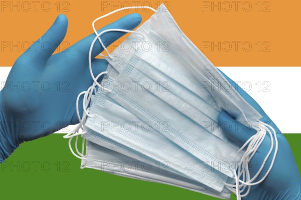 Doctor holding face masks in hands medical blue gloves on background national flag of India. Concept coronavirus quarantine, pandemic outbreak, grippe, hygiene. Surgical antibacterial face bandage