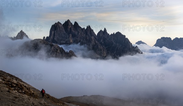 Unrecognised man trekking late in the evening at the hikking path of the picturesque Dolomites at Tre Cime area in South Tyrol in Italy