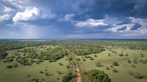 Aerial view of Transpantaneira dirt road with dramatic sky and rain crossing the typical landscape in North Pantanal Wetlands, Mato Grosso, Brazil