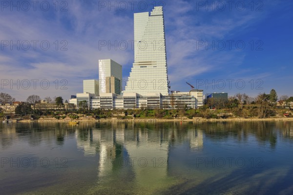 Towering buildings are reflected in the calm water under a blue sky, pharmaceutical company Roche, skyscrapers, towers, Rhine, Basel, Switzerland