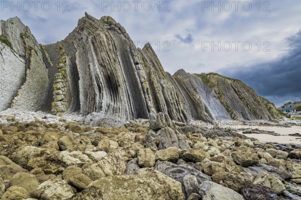 Portio Beach, Cantabria Beaches. Giant rough gray rocks and smooth sandy beach. Noon on the beach of Playa di Arnia, Spain. Windy stormy day on the Atlantic coast