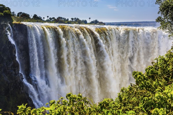 Journey after the wet season. Grand and deep Victoria Falls after the rainy season. Victoria National Park, the Zambezi River. Concept of extreme and photo tourism