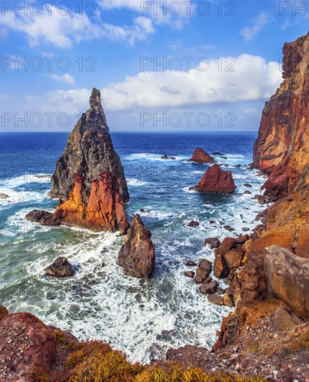 The sharp red rocks, boiling turquoise surf. The blinding midday sun illuminates the rocky shore. Madeira is a magical island in the Atlantic. The concept of active, ecological and photo tourism