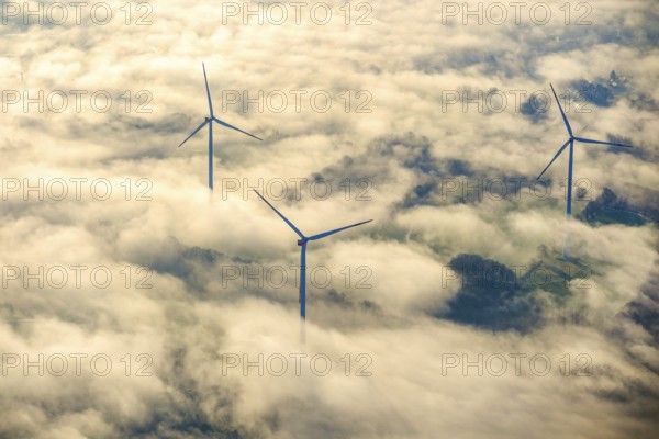 Wind turbines in the wintry morning mist protrude from the fog layer in the Haltern and Marl area. North Rhine-Westphalia, Germany