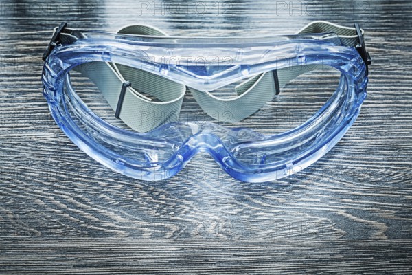 Safety plastic goggles on wooden board