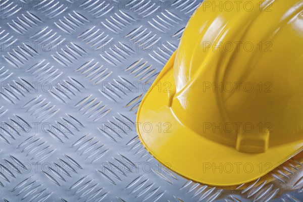 Safety hard hat on channeled metal background construction concept