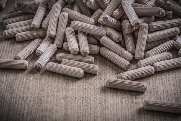 Variety of cylinder wooden dowels on wood board construction concept