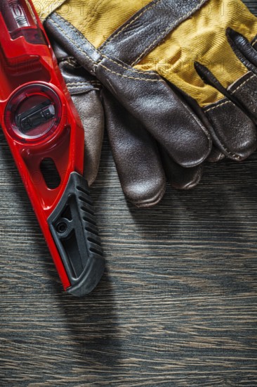 Construction level protective gloves on wooden board