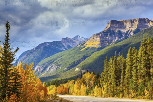 Canada, Alberta, Rocky Mountains. Highway in Banff National Park. Mountains and colorful autumn forest illuminated by the sunset