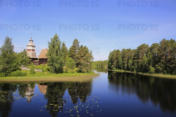 Finnish blue lake and sky landscape with UNESCO World Heritage site, old wooden church of Petajavesi, Finland in summer. The church was built 1763-65