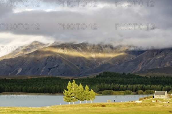 Sun breaking through the clouds over Lake Tekapo and the Church of the Good Sheppard on the South Island of New Zealand