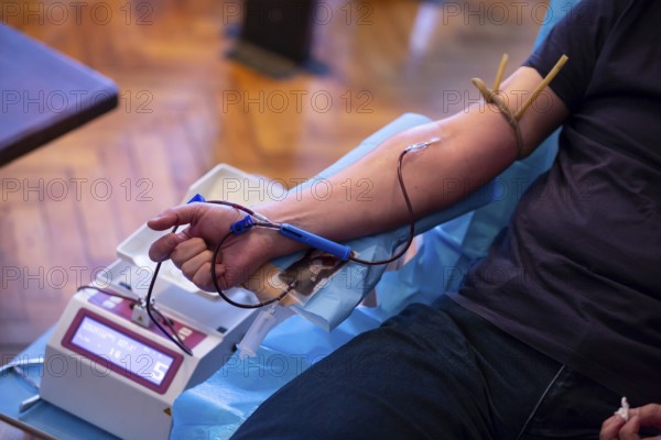 The hand of a man who donates blood. Male donor gives blood in a mobile blood donation center. Blood samples