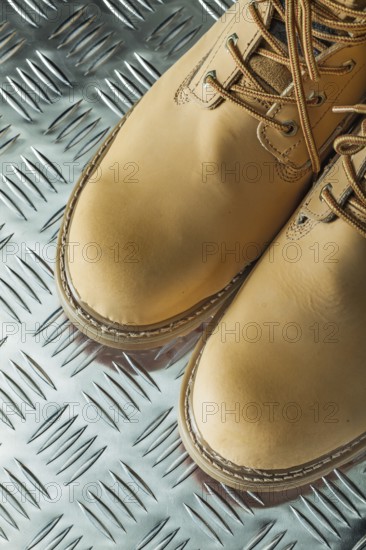 Waterproof safety boots on corrugated metal sheet