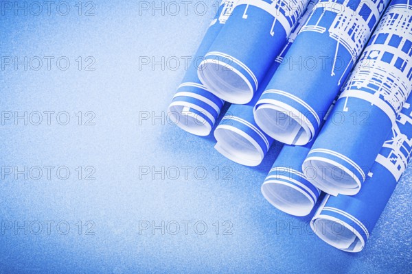 Stack of engineering drawings on blue background top view